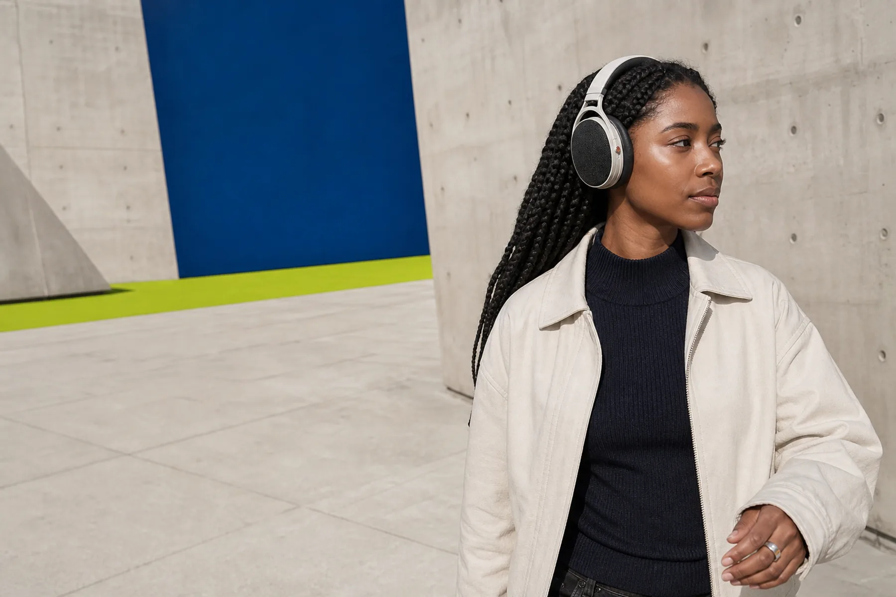 Listener wearing bone ORA headphones while moving through a city plaza